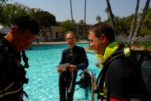 Divers doing a pre-dive safety check.  Rescue Divers should make sure other divers do a pre-dive check to prevent problems.
