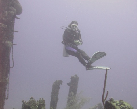 Weightless scuba diver hovering over a wreck